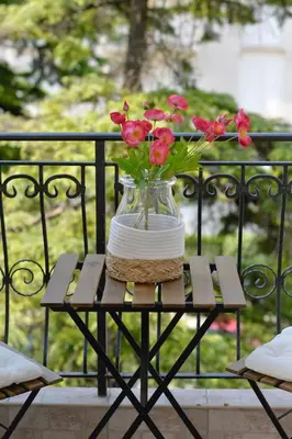 a vase with red flowers sitting on a table at The Nest - Urban Family place in Kotor