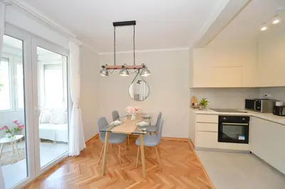 a kitchen and dining room with a table and chairs at The Nest - Urban Family place in Kotor