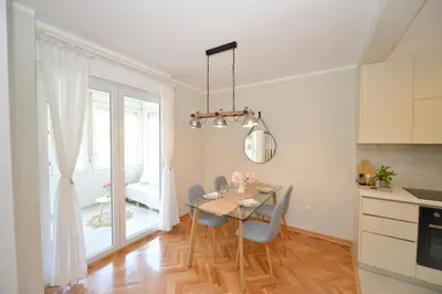 a dining room with a table and chairs in a kitchen at The Nest - Urban Family place in Kotor