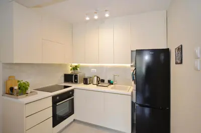 a kitchen with white cabinets and a black refrigerator at The Nest - Urban Family place in Kotor