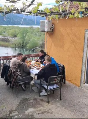 a group of people sitting at a table eating food at Sunny balconies apartments Skadar Lake in Virpazar