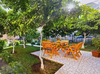 a wooden table and chairs under a tree at Apartments Dalila in Ulcinj