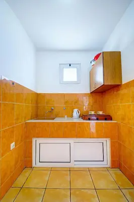 a kitchen with orange tiled walls and a sink at Apartments Dalila in Ulcinj