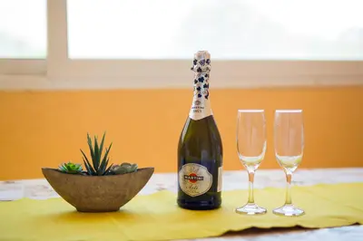 a bottle of champagne and two wine glasses on a table at Apartments Dalila in Ulcinj