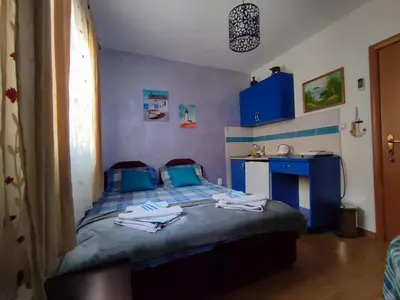 a bedroom with a blue bed with towels on it at Apartments Blago Sutomore in Sutomore