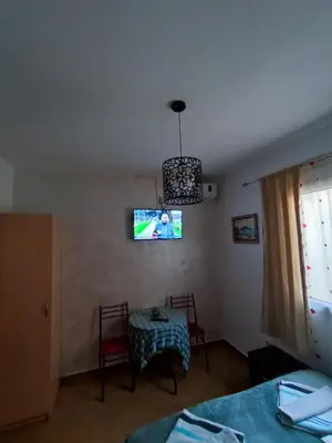a room with a table and a tv on the wall at Apartments Blago Sutomore in Sutomore