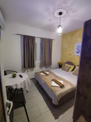 a bedroom with a large bed and a table at Apartments Blago Sutomore in Sutomore