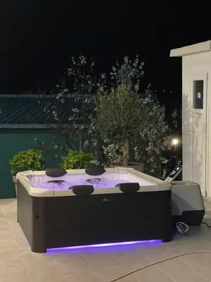 a hot tub sitting on a patio at night at Apartments Miona in Virpazar