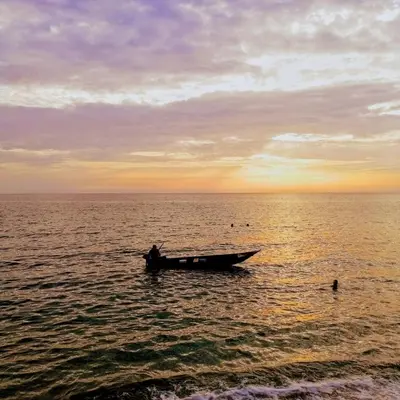 a boat in the middle of the ocean at sunset at Apartments Miona in Virpazar