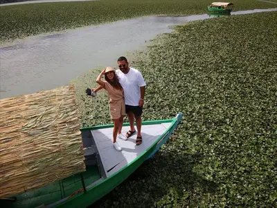 a man and a woman standing on a boat at Apartments Miona in Virpazar