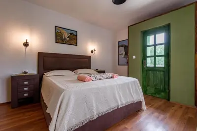 a bedroom with a bed and a green door at Apartments Miona in Virpazar