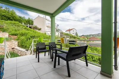 a porch with chairs and a view of a hill at Apartments Miona in Virpazar