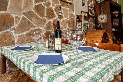 a table with two glasses and a bottle of wine at Apartments Miona in Virpazar