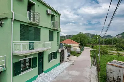 a green building with balconies and a street at Apartments Miona in Virpazar