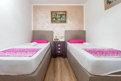 two beds sitting next to each other in a room at Apartments Miona in Virpazar
