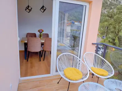 a room with chairs and a table and a balcony at Apartment Dora in Kotor