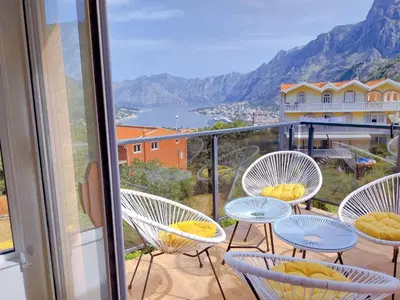 a balcony with chairs and a view of the mountains at Apartment Dora in Kotor