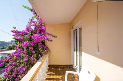a balcony with purple flowers on a building at Guest House Lotos in Becici