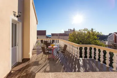 a balcony with a table and chairs on it at Guest House Lotos in Becici