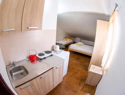 a small kitchen with a sink and a stove at Guest House Lotos in Becici