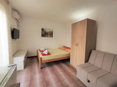 a small room with a bed and a cabinet at Guest House Lotos in Becici