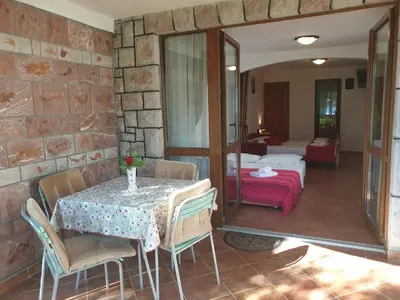 a room with a table and chairs and a bedroom at Zoro Apartments in Sveti Stefan