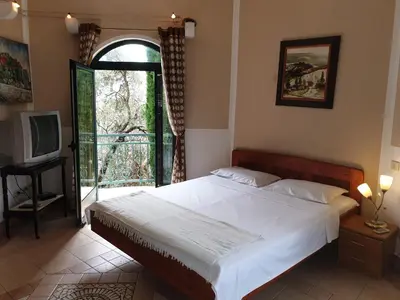 a bedroom with a bed and a window and a television at Zoro Apartments in Sveti Stefan