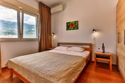 a hotel room with a bed and a window at Montesun Apartments in Budva