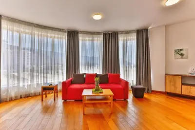 a living room with a red couch and large windows at Montesun Apartments in Budva