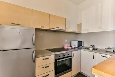 a kitchen with white appliances and wooden cabinets at Montesun Apartments in Budva