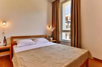 a bedroom with a large bed with a window at Montesun Apartments in Budva