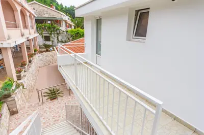 an external view of a white house with stairs at Apartmani Steni in Sveti Stefan