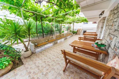 a row of benches in a building with trees at Apartmani Steni in Sveti Stefan