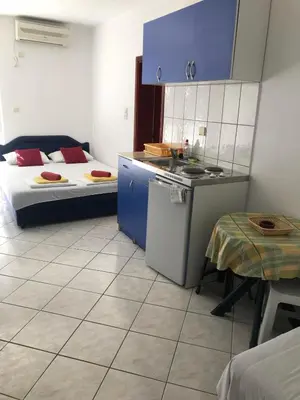 a room with two beds and a kitchen and a table at Stojko Rafailovici in Rafailovici