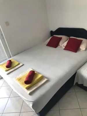 a bed with red and yellow towels on top of it at Stojko Rafailovici in Rafailovici