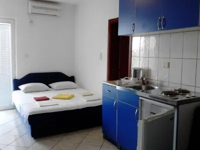 a small kitchen with a bed and a sink at Stojko Rafailovici in Rafailovici