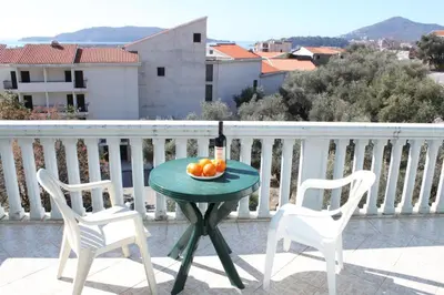 a table with a bowl of fruit on a balcony at Stojko Rafailovici in Rafailovici