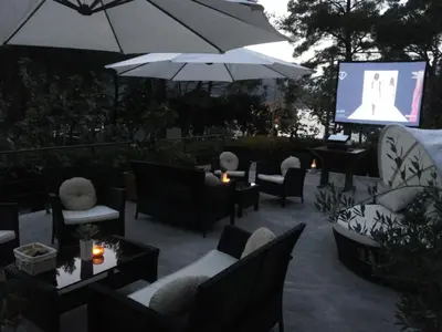 a patio with couches and chairs and a screen at Apartments Vojvoda in Kotor