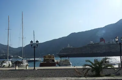 a cruise ship is docked at a dock with boats at Apartments Vojvoda in Kotor