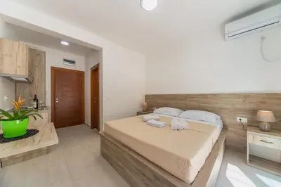 a bedroom with a bed with two towels on it at GREJM Lux Family Apartments in Petrovac na Moru