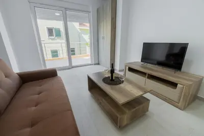 a living room with a couch and a television at GREJM Lux Family Apartments in Petrovac na Moru