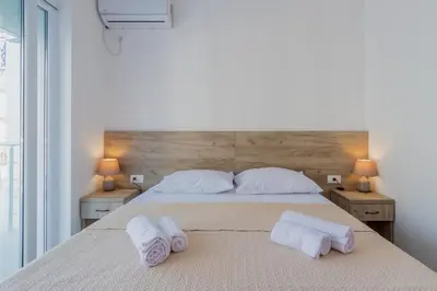 a bedroom with a bed with towels on it at GREJM Lux Family Apartments in Petrovac na Moru