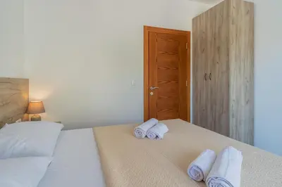 a bedroom with a bed with towels on it at GREJM Lux Family Apartments in Petrovac na Moru