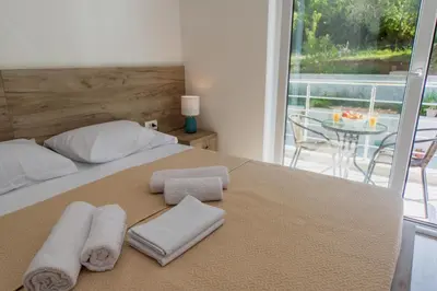 a bedroom with a bed with towels on it at GREJM Lux Family Apartments in Petrovac na Moru