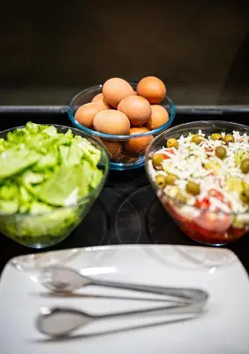 a table with bowls of food and bowls of salad at Hotel Resurs in Podgorica