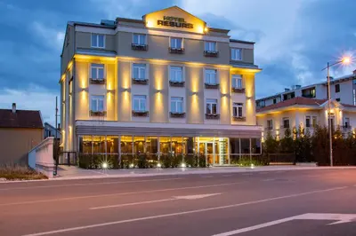 a hotel with a lit up facade on a street at Hotel Resurs in Podgorica