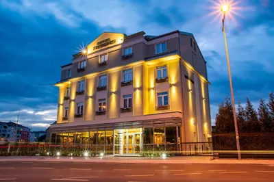 a large building with a light lit up at night at Hotel Resurs in Podgorica