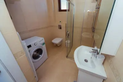 a bathroom with a washing machine and a sink at Belvedere Apartments in Petrovac na Moru