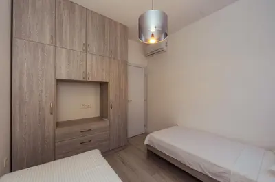 a bedroom with two beds and a wooden cabinet at Belvedere Apartments in Petrovac na Moru