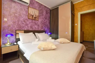 a bedroom with a bed and a purple wall at Apartment Golden Lavender in Budva
